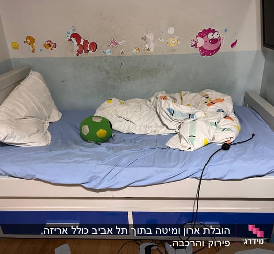 מיטה עם מצעים כחולים וכרית ירוקה